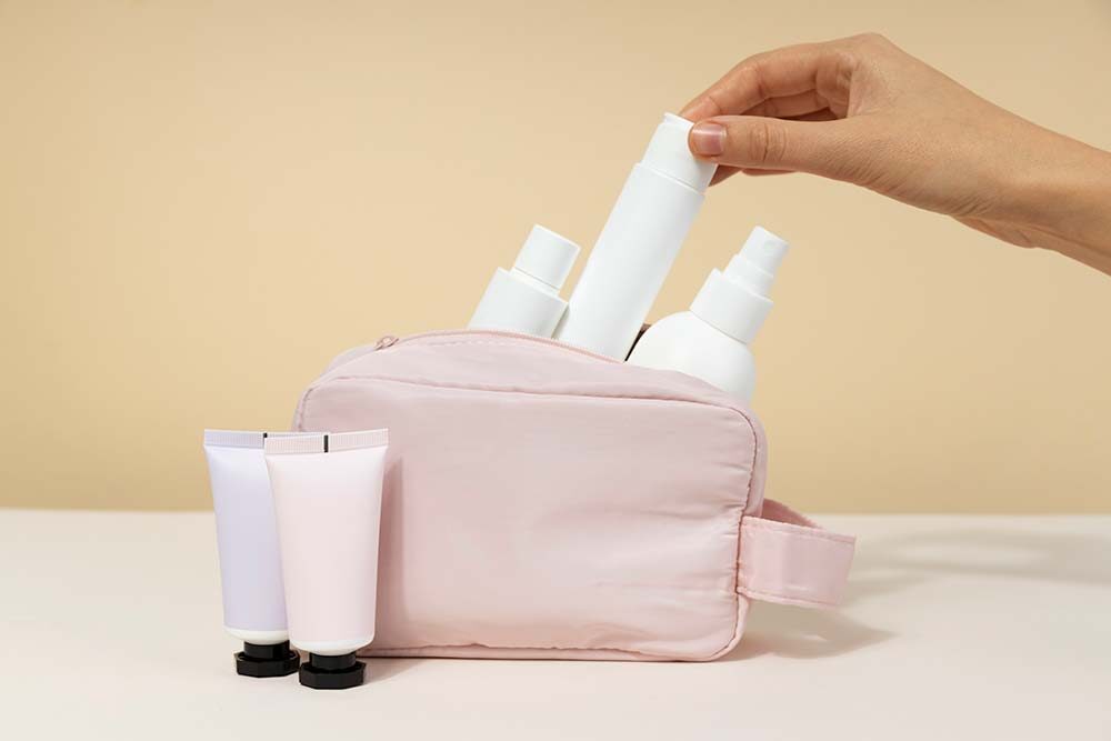 Functional beauty packaging with tubes, pumps, and sprays in a travel pouch.