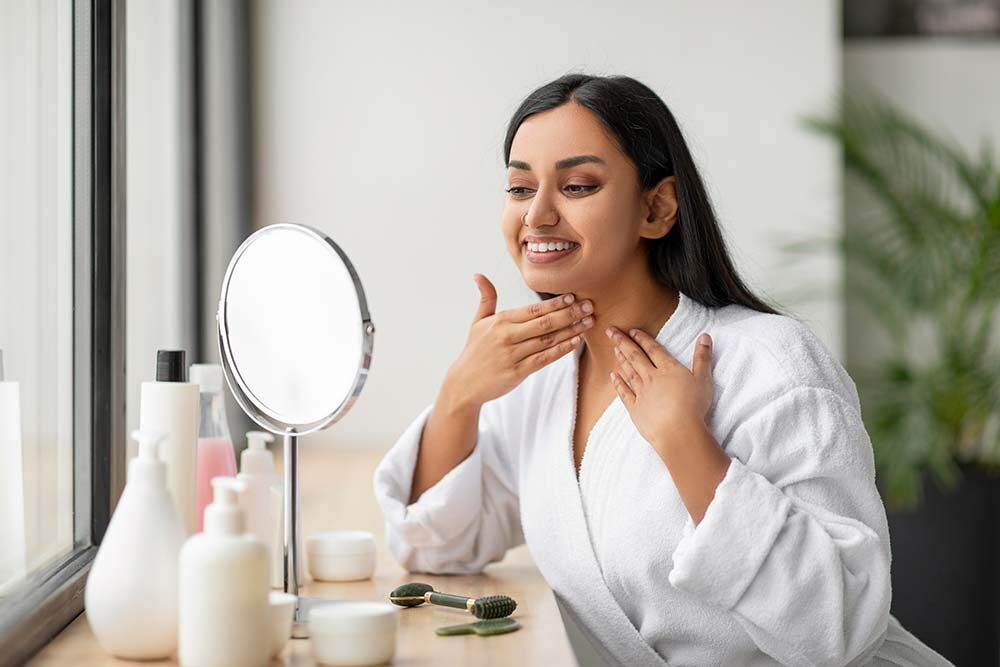 Indian woman checking healthy glowing skin after pH balanced skincare routine