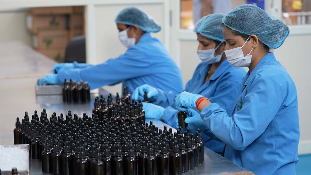 Workers inspecting skincare bottles during quality checks